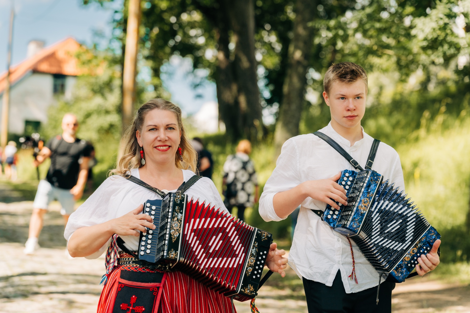 Naine ja noormees lõõtspille mängimas suvepäeval